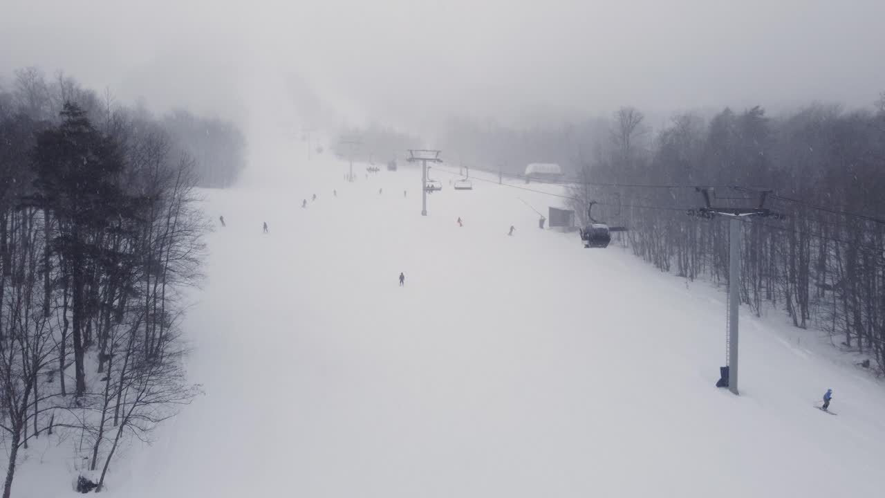 Snowy mountains covered in thick fog with the slopes barely visible, Orford, Quebec, Canada