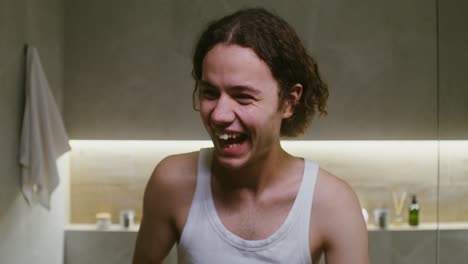 man using jade roller in bathroom