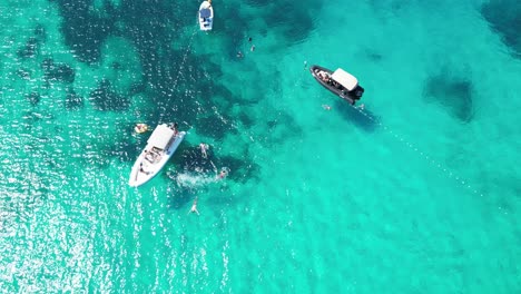 vista aérea de las islas paklinski cerca de hvar, croacia, con aguas claras y barcos navegando mientras los amigos se sumergen en el agua