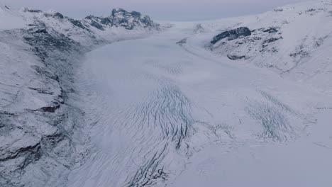 Aerial-landscape-view-of-Skaftafellsjokull-glacier-in-Iceland,-covered-in-snow,-at-sunset