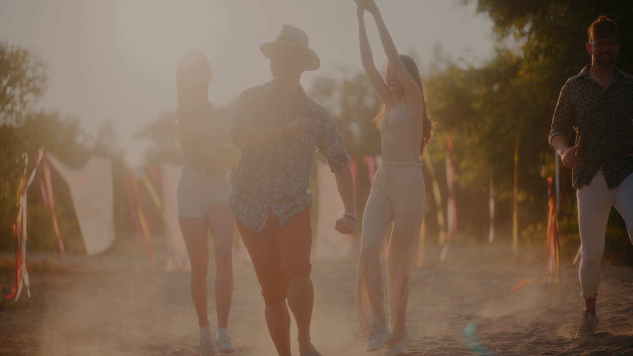 Happy carefree young men and women running at beach
