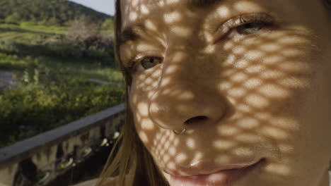 closeup portrait of beautiful caucasian glamour woman wearing black nose ring in a summer day with shadow net reflection from metal sunshade on her face