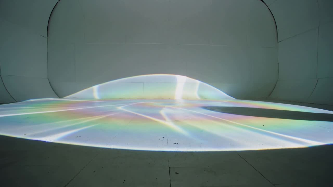 Vertical video: Powering projector casting rainbow dome flattening on studio floor, showing seams