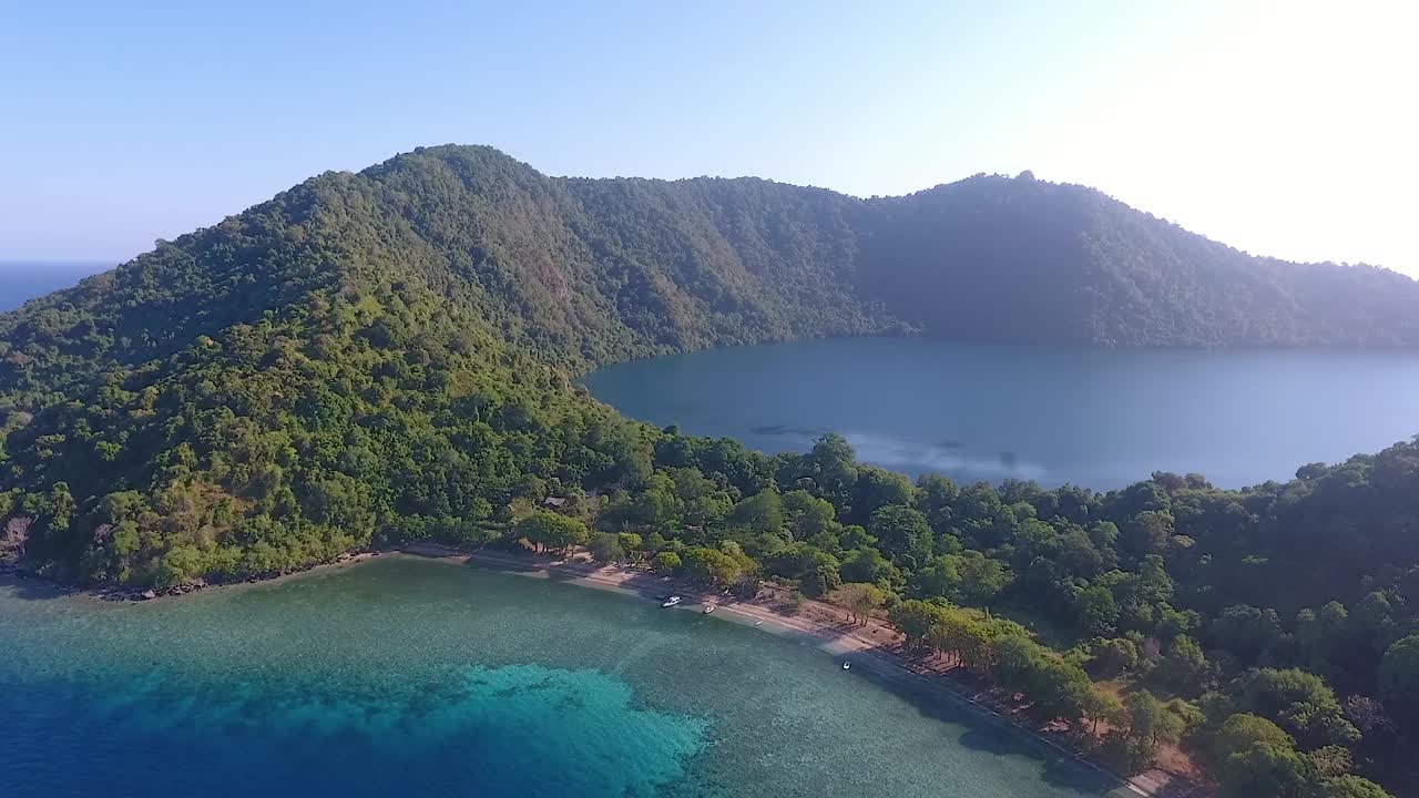 Aerial panorama of volcanic Satonda Island with caldera lake in East Indonesia
