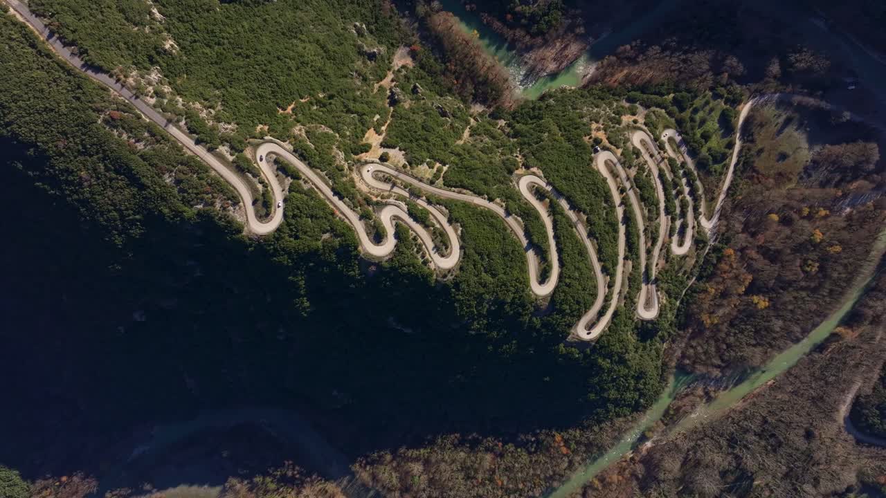 Aerial frame of cars driving through twisting mountain path, Epirus