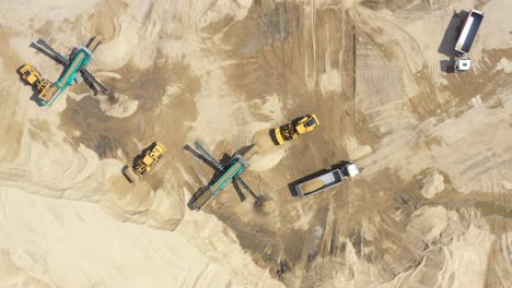 aerial view, machinery working at clay quarry, heavy loaders, large trucks, bulldozers, excavators, sand quarry, mining, truck takes raw materials from the quarry, large clay warehouse