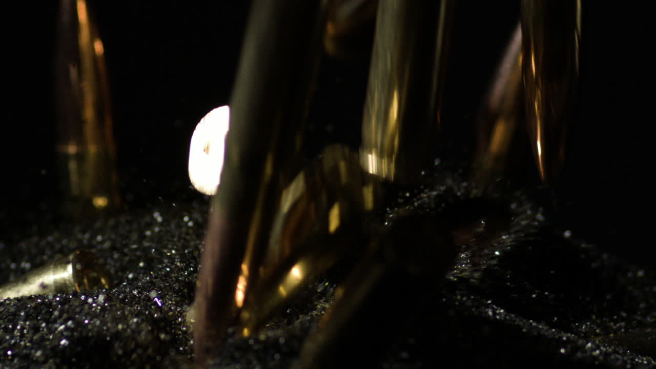 .300 AAC Blackout bullets falling on pile of gunpowder in slow motion, macro