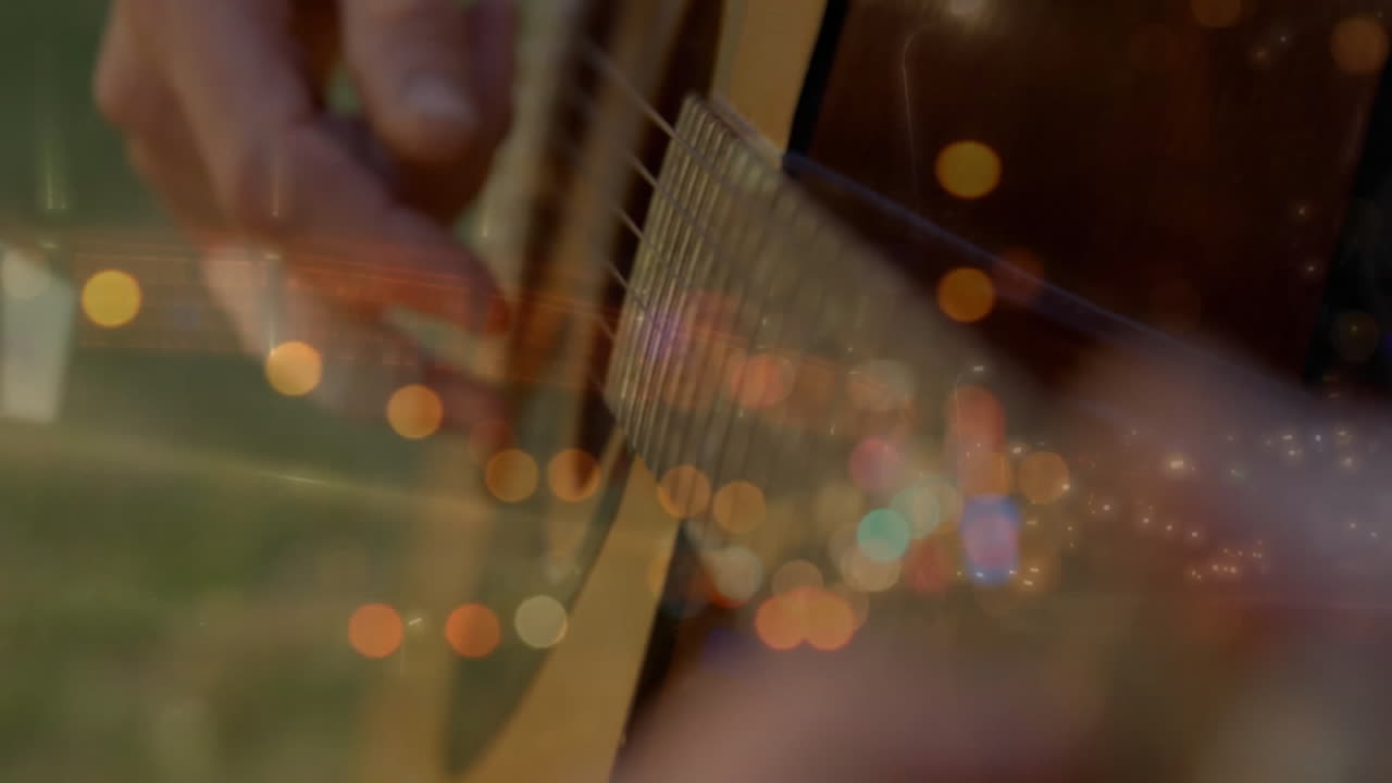 Playing guitar strings over blurred city lights, creating musical animation