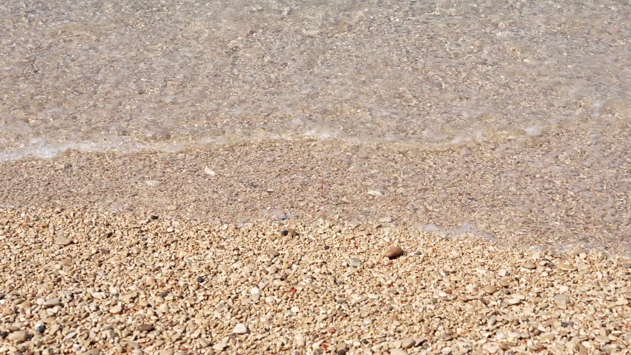 Ondas suaves do oceano banhando uma praia de seixos
