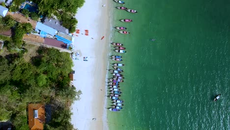 toma estática aérea de botes de cola larga atracados en la playa