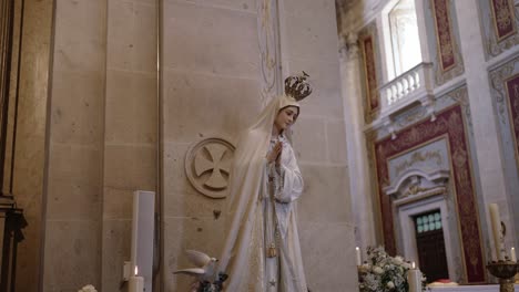 Elegant statue of Virgin Mary with crown and candles in a church setting
