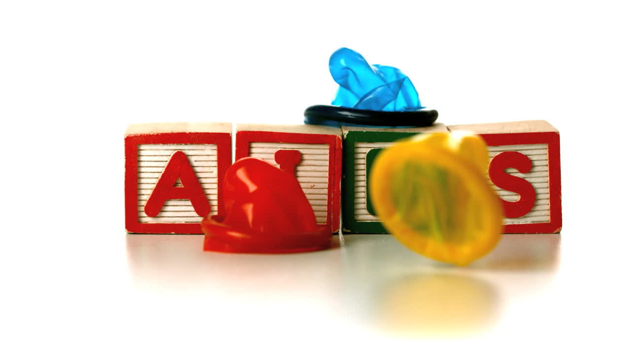 Colourful condoms falling on blocks spelling AIDS