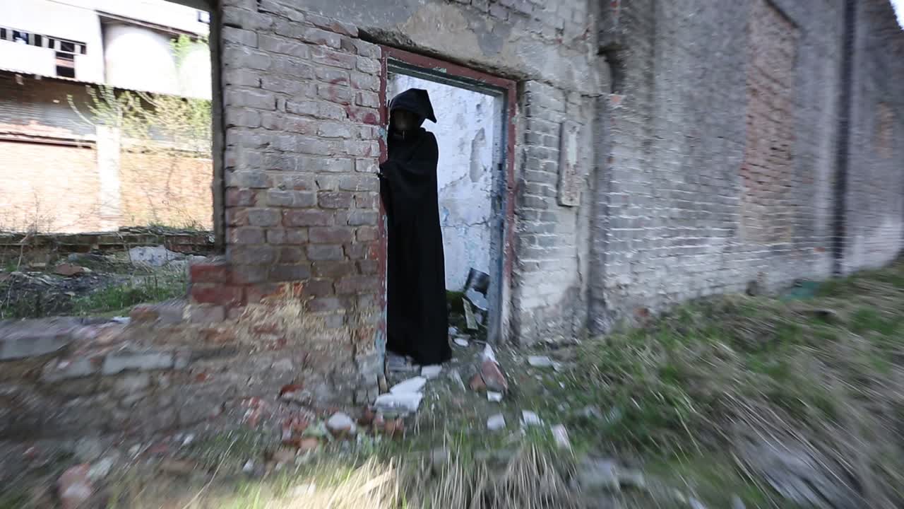 Ghost In Destroyed Building. Ghost in black cloak walking throug destroyed building