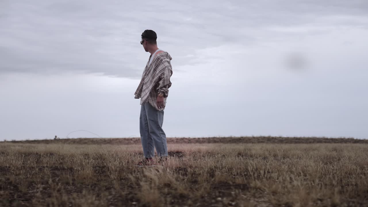 Asian male model lost in the middle of dry grassland