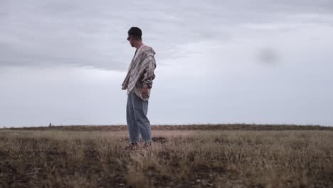 asian male model lost in the middle of dry grassland
