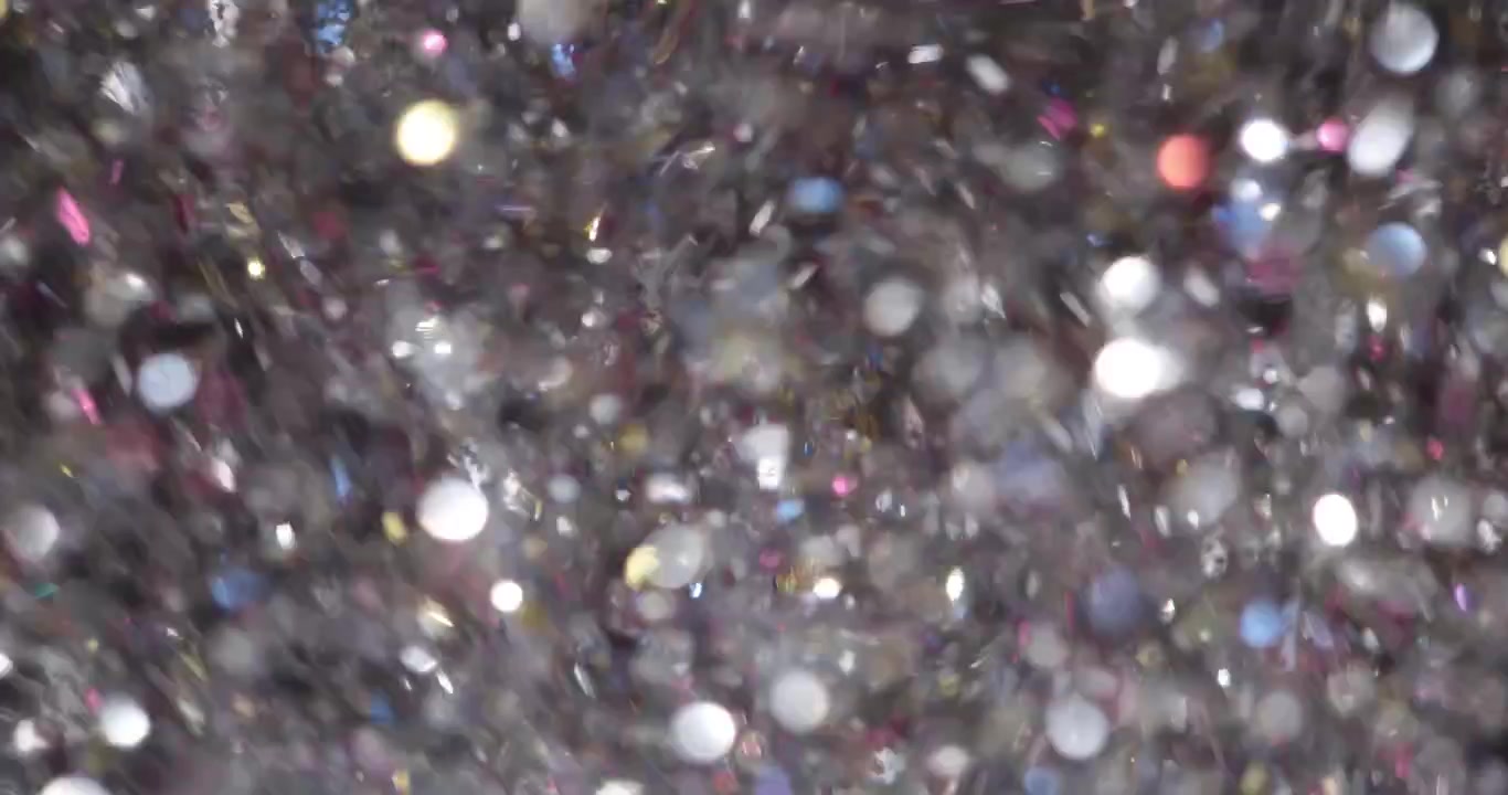 Confettis argentés captent la lumière et scintillent en descendant