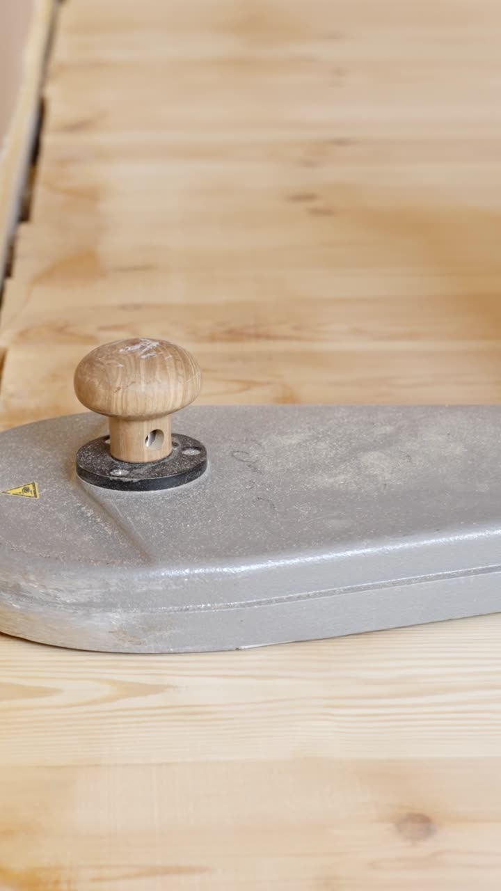 Sander slowly moved across wooden floor edge during renovation process, tool in view