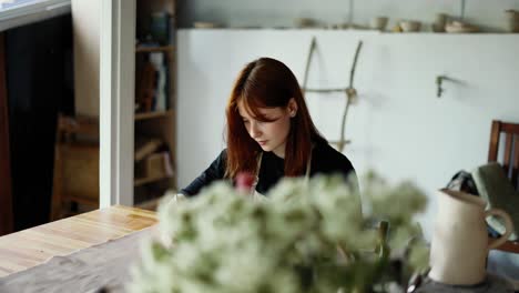 a red-haired girl draws a scheme of her product on paper with a pencil