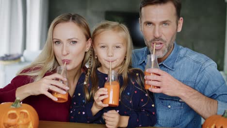 cheerful family drinking pumpkin smoothie