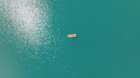 Toma-Aérea-De-Un-Barco-En-El-Río-Azul-Subiendo,-Lago-Di-Braies,-Italia,-Dolomitas