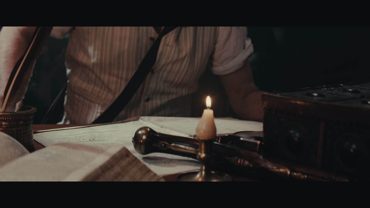 An old captain sits down by the old table inside the sailing ship cabin and writes a letter