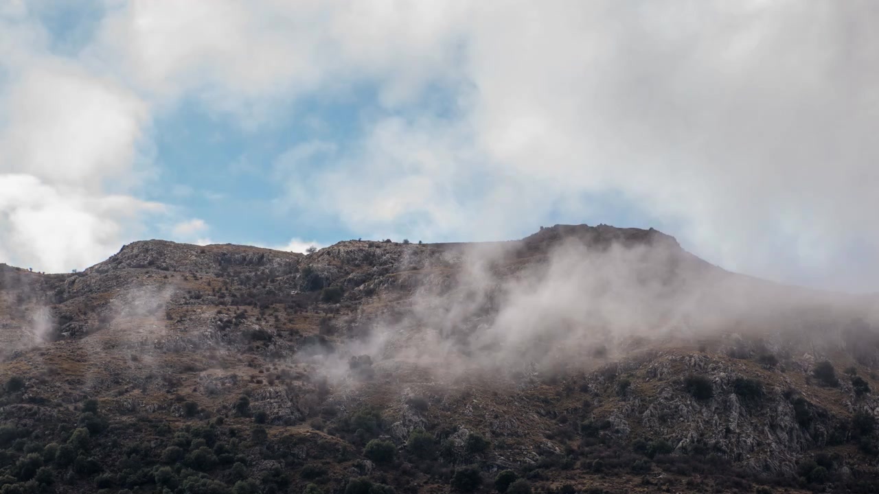 Nuvens se movendo sobre um pico