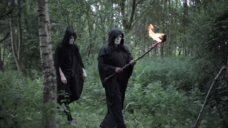 un culto de druidas encapuchados malvados camina por el bosque y está a punto de realizar un ritual de sacrificio