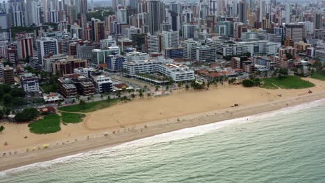 toma aérea giratoria del famoso destino turístico tambaú beach en la capital tropical de joao pessoa en paraiba, brasil con carpas vibrantes alineadas para los visitantes