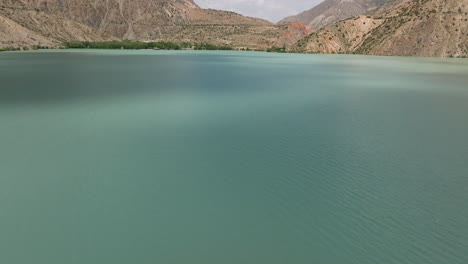 el lago iskanderkul con aguas tranquilas en tayikistán - fotografía aérea