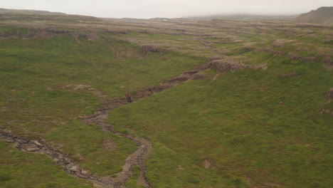 Water-streams-in-Iceland's-misty-westfjords,-drone-shot