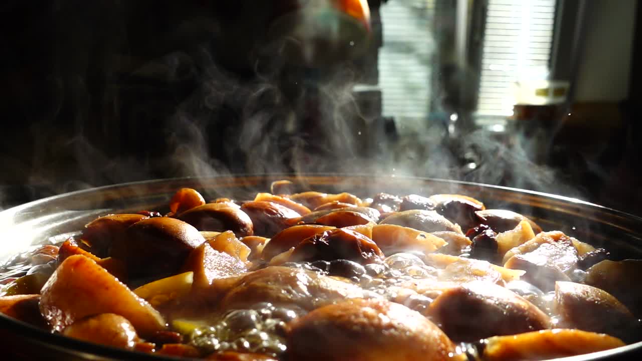 Cocinando fruta en compota. Cámara lenta. La compota se cocina en una olla.