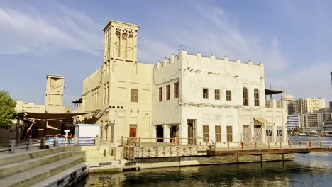 Blick-Vom-Dubai-Creek-Auf-Ein-Traditionelles-Gebäude-Mit-Windturm-Im-Historischen-Viertel-Al-Fahidi-In-Dubai,-Vereinigte-Arabische-Emirate