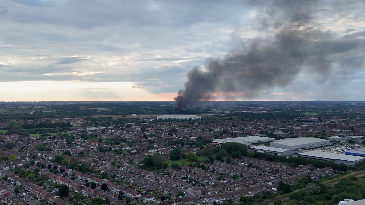 Vista aerea di un'ampia colonna di fumo nero da un incendio lontano sopra una città