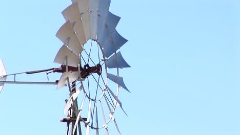 mediumshot of windmill blades spinning in the wind