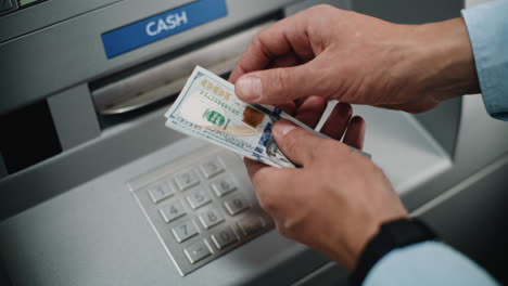 person receiving cash from atm