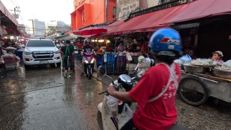 people navigating a busy wet market road