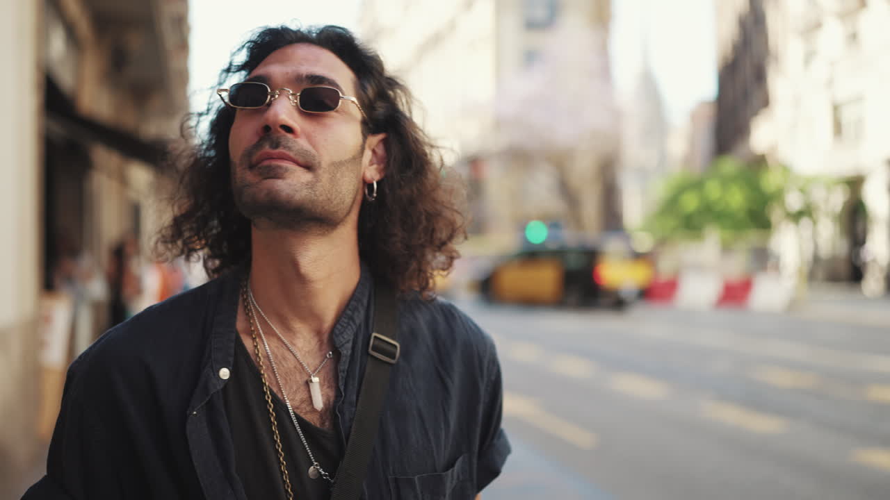 Man with Curly Hair and Sunglasses in City Street