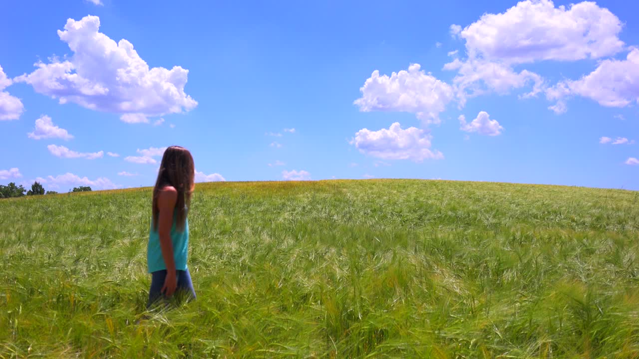 예쁜 소녀가 머리를 휘날리며 들판을 걷고 있다