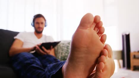 man using digital tablet in living room