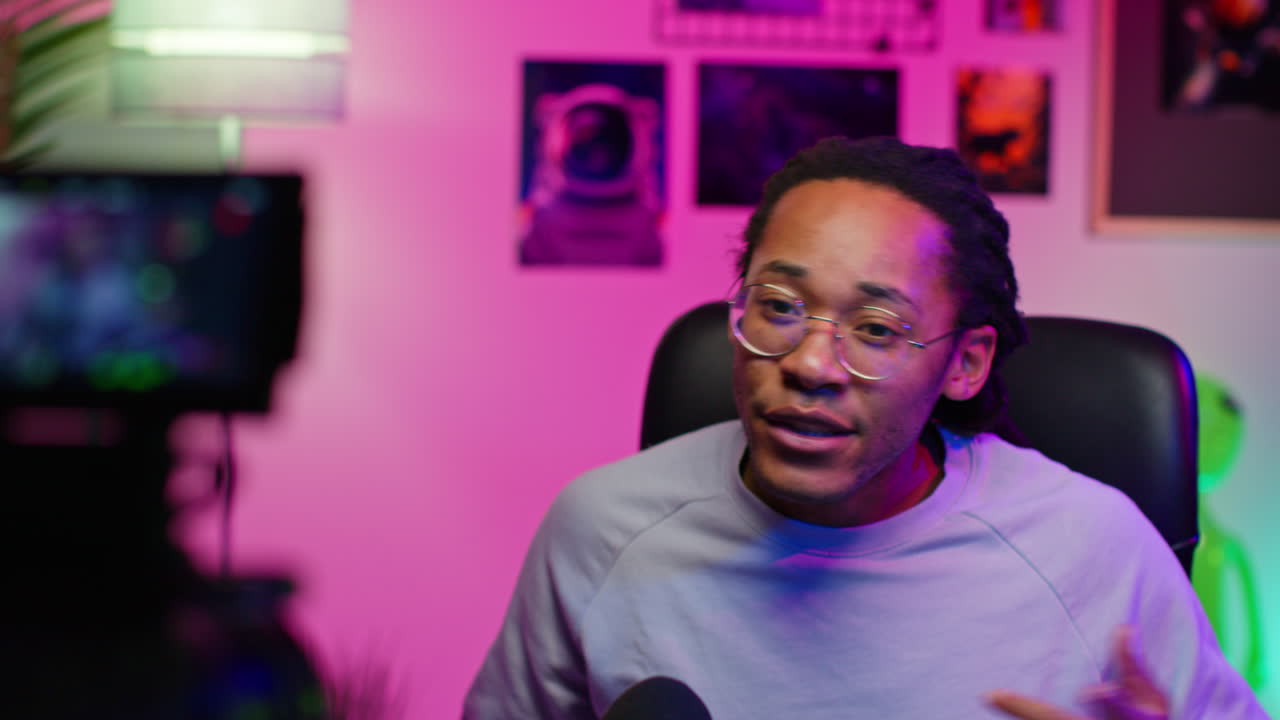 Man with dreadlocks talks to the camera while streaming