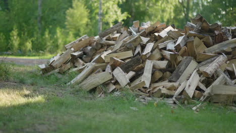 slow panning shot of wood flying into a pile of firewood - preparing for a cold winter