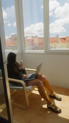 mujer trabajando desde casa en el balcón