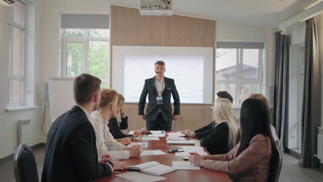 business coach is greeting participants of conference or business meeting men and women applauding