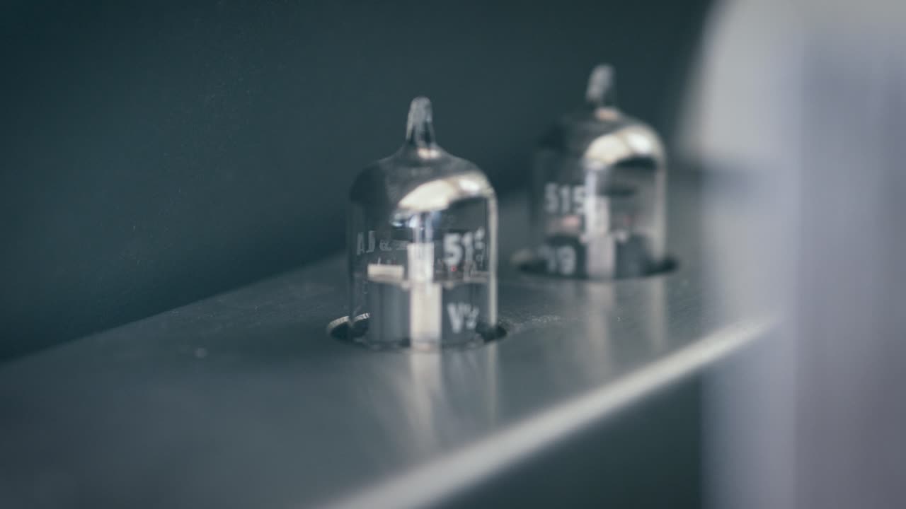 Turning on power vacuum tube amplifier. Electronic device amplifier with glowing bulb, old-fashioned. Scene B.