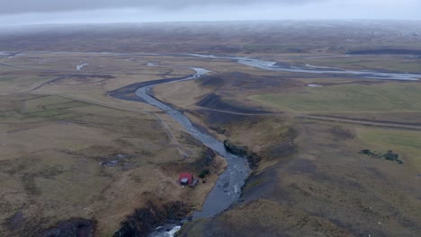 aerial drone shot of sela rriver running in a magnificent landscape of iceland during grey clouds at sky