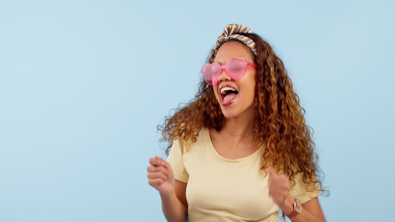 Happy, dancing and young woman in a studio