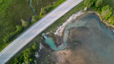 Aerial-topdown-ascent-of-Quarry-lake-stream-water-emptying-into-Lake-Huron,-Michigan