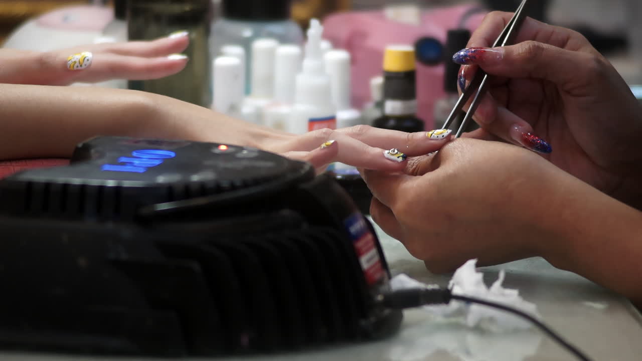 Close-up of a woman receiving a professional hand and nail manicure at a beauty salon. Focus on female hands, skincare, and nail care treatment