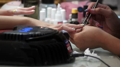 close-up of a woman receiving a professional hand and nail manicure at a beauty salon. focus on female hands, skincare, and nail care treatment