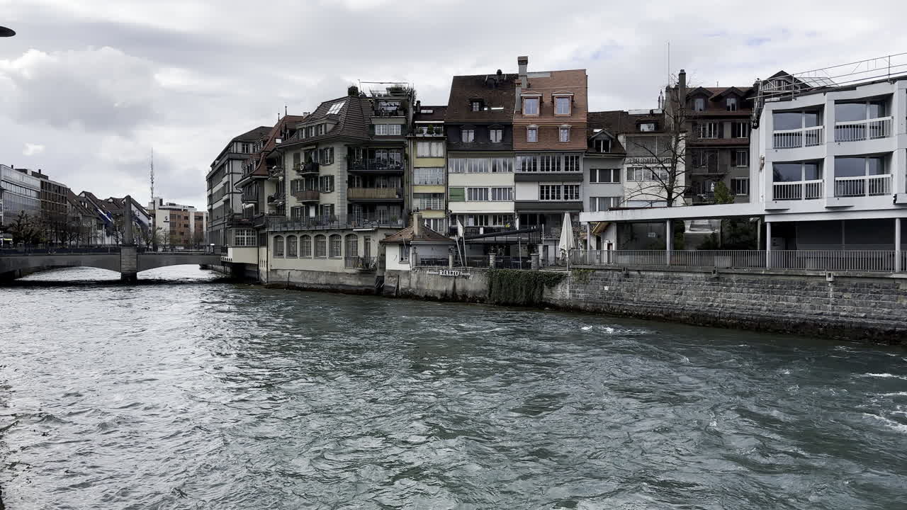 Lake Thun flowing peacefully with houses next to it